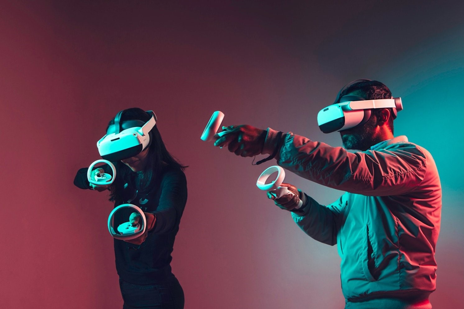 2 People wearing VR Headsets and playing with controllers